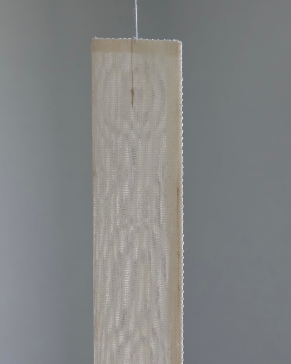 Close-up of the Oksa Silk Mobile's woven silk slat panel with pinked edges