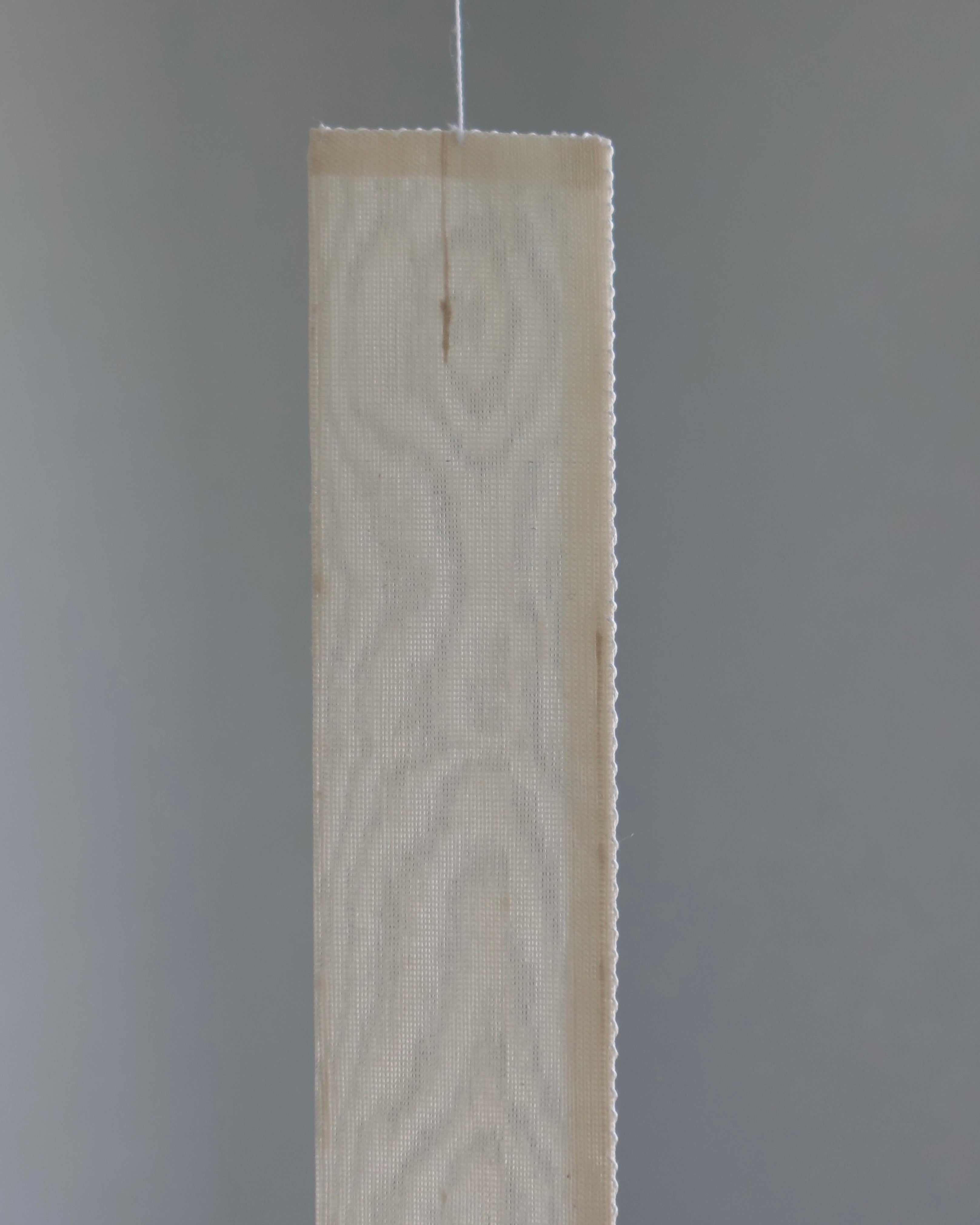 Close-up of the Oksa Silk Mobile's woven silk slat panel with pinked edges