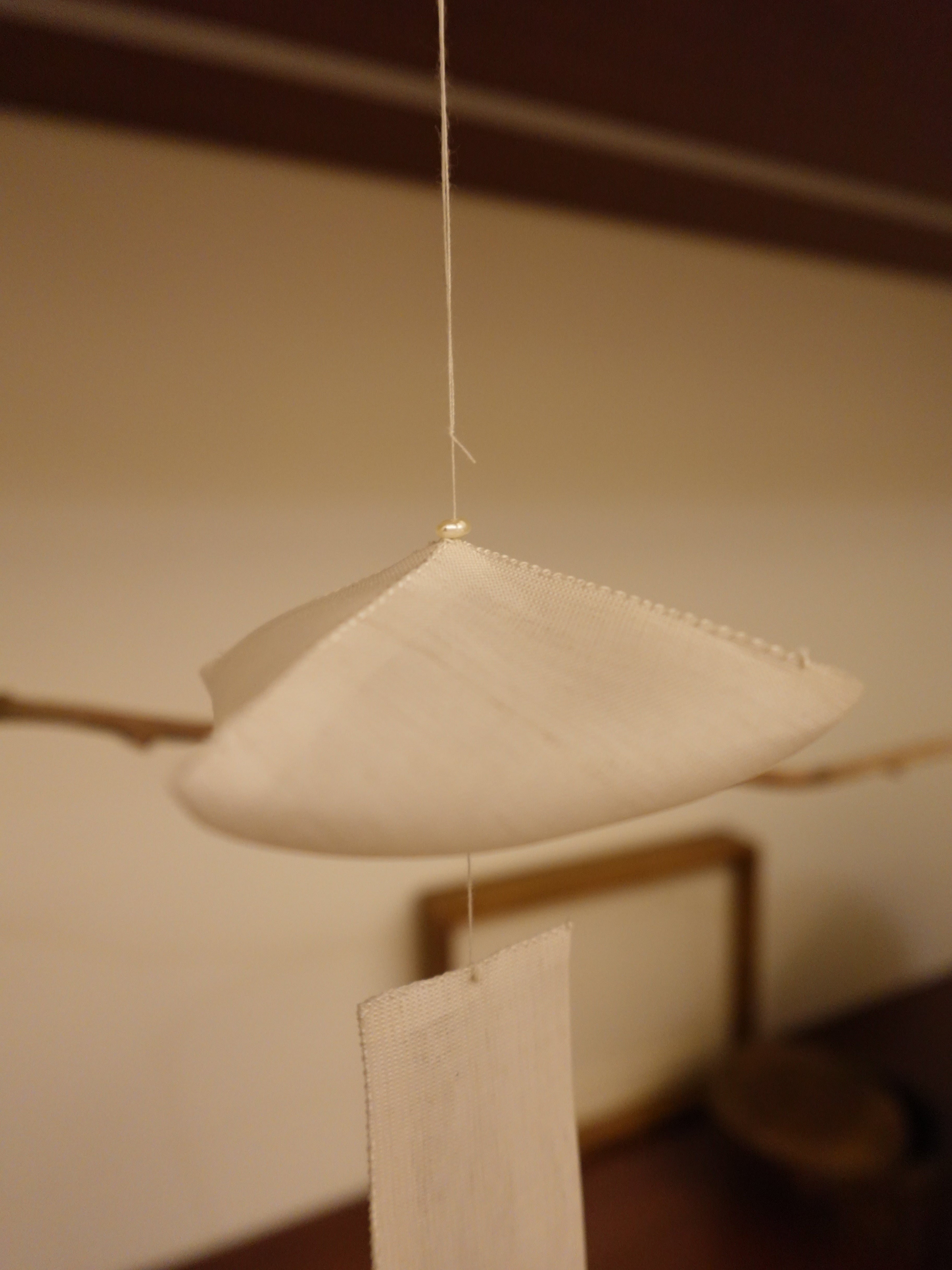 Close-up of the Oksa Silk Mobile's gathered silk dome and freshwater pearl crown